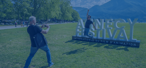 A man jumping in front of the Annecy Festival sign - ANNECY FESTIVAL/G. Piel