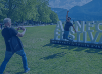 A man jumping in front of the Annecy Festival sign - ANNECY FESTIVAL/G. Piel
