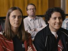 Young man and young lady sitting in a courtroom @ Sequel Prod / RTBF / Proximus