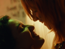 Two girls with their face close to each other's.
