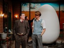 Two actors are tallking in front of a set with a giant white egg. © Panenka en Ilias Van Bambost
