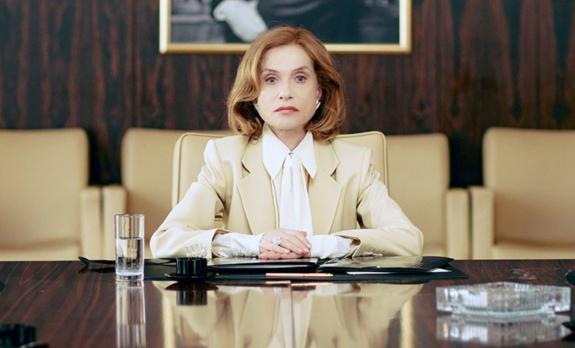 Rich lady sitting in front of a large desk with work papers on it. 